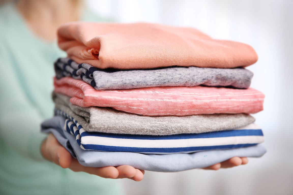 Person Holding Folded Clothes